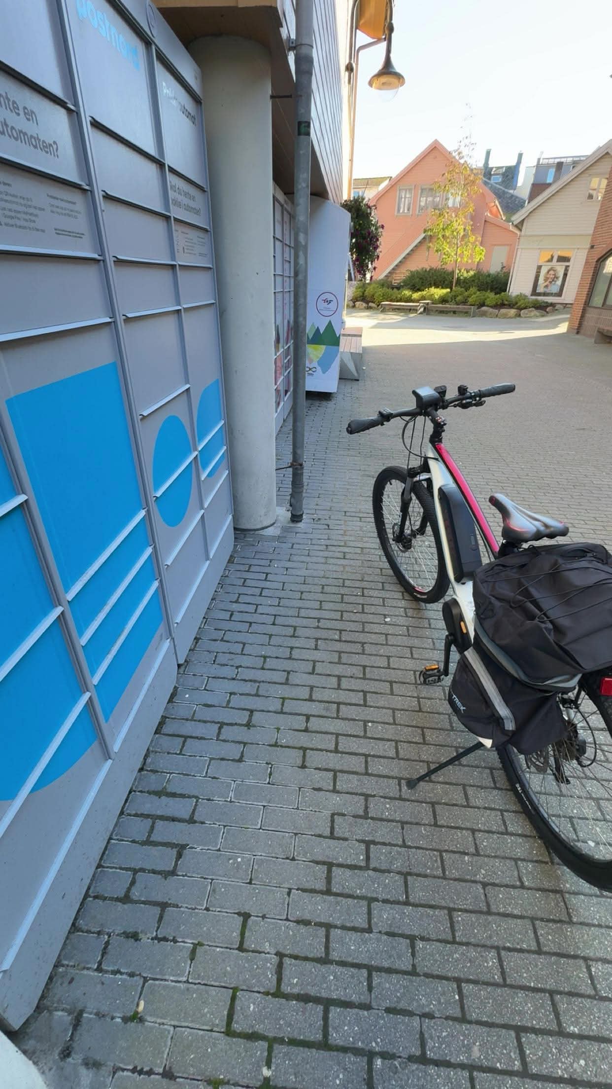 An e-bike parked by a parcel locker on a quiet street
